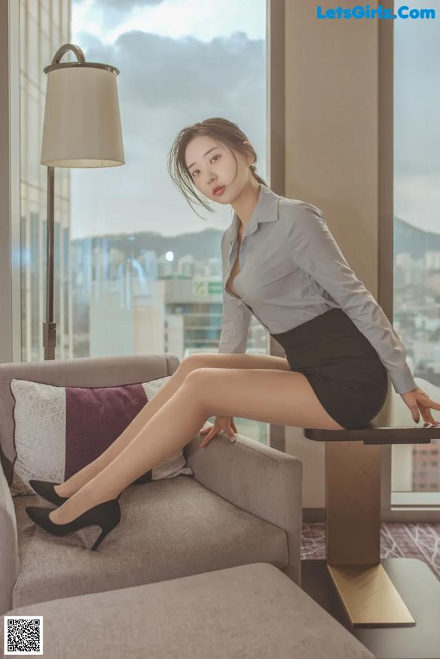 A woman sitting on a couch in a room.