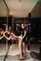 A group of women standing in front of a mirror.