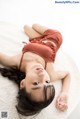 A woman laying on top of a white rug.