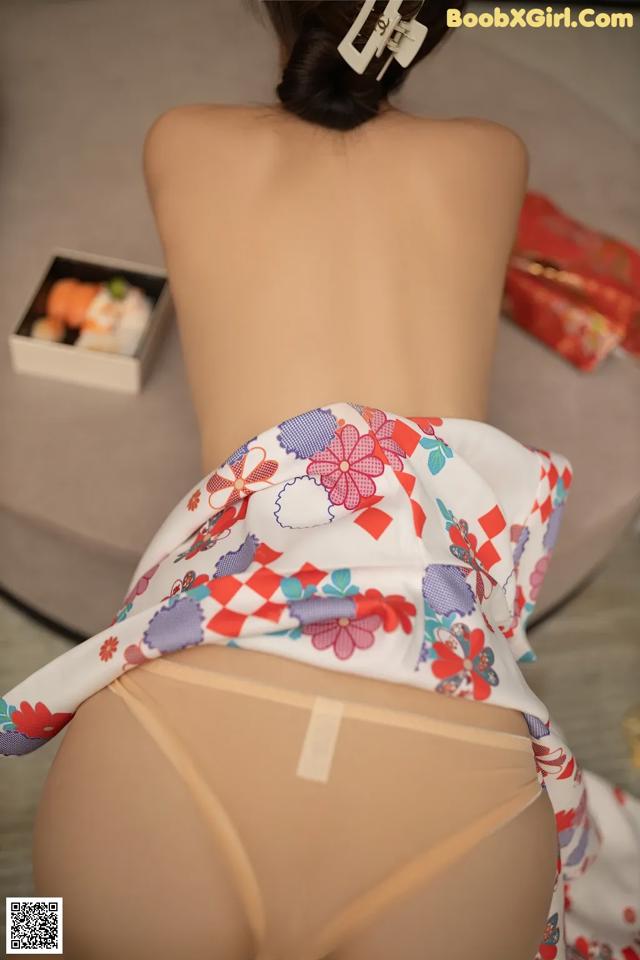 A woman in a kimono is sitting on a bed.