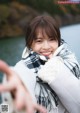 A young woman wearing a scarf and smiling at the camera.