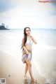 A woman in a white bikini standing on a beach.